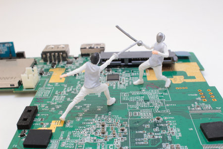 Two small-scale fencing figures are staged on a green circuit board
