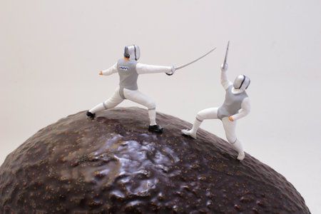 Creative conceptual scene featuring miniature figures fencing on the textured