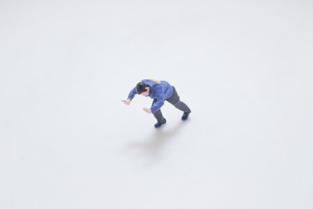 A small plastic figure in a blue jacket is captured mid-stretch