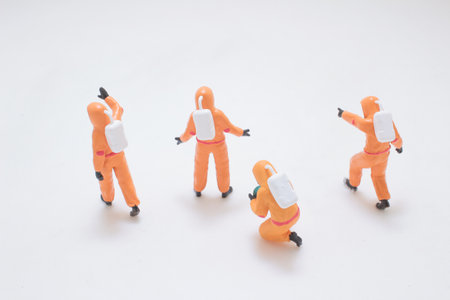 Colorful miniature figures in orange suits interact in a playful