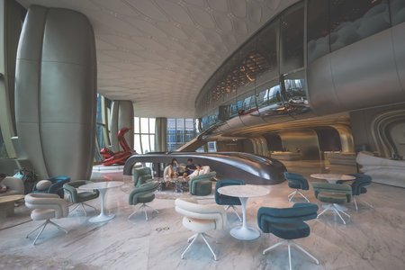 A sleek, futuristic lobby with an escalator, curved white pillars,