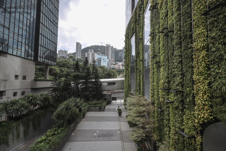 contemporary urban scene featuring a vertical green wall on a glass building, surrounded