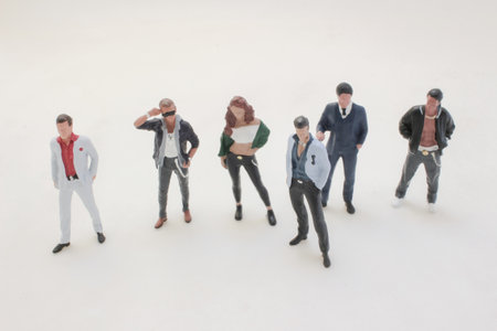 Six male figurines stand in a line on a clean white backdrop,の写真素材
