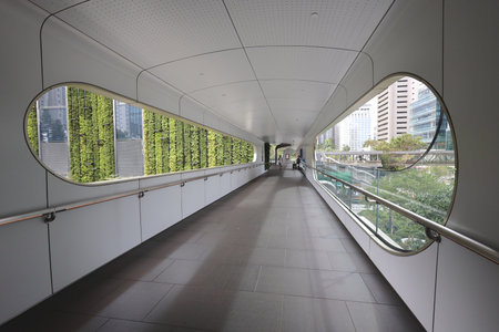 A sleek enclosed walkway connects city districts, featuring large oval windowsのeditorial素材