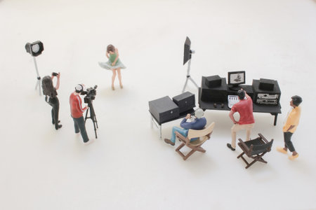 A miniature film crew captures a couple in bathrobes on a bedroom set.の写真素材