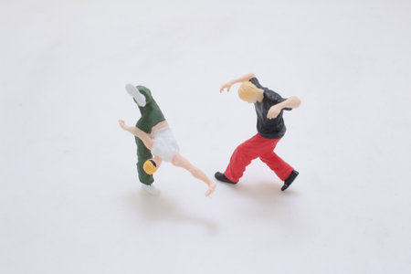 Two small figurines capture a high-energy breakdance moment: