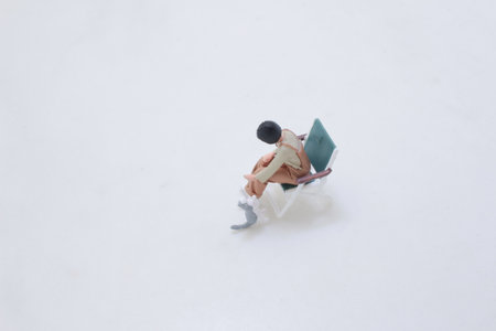 A tiny figurine sits in a green chair while a small petの写真素材
