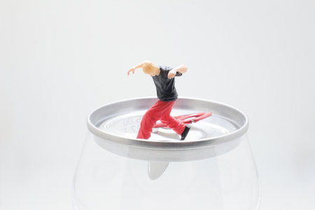 Whimsical miniature figures balance on a metal can