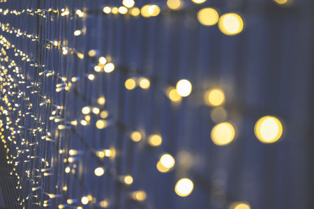 Nov 15 2025 Golden string lights shimmer along a deep blue backdrop,の写真素材