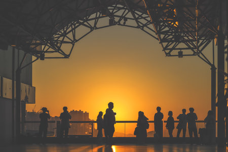 Silhouetted visitors line a waterfront promenade as the sun sets Nov 16 2025のeditorial素材