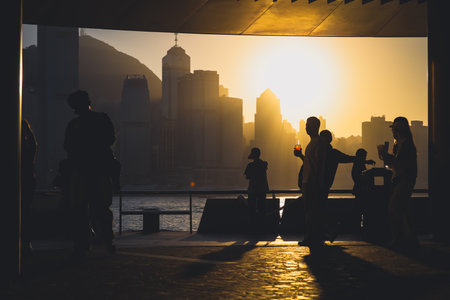 Golden sunset over a modern city skyline casts long shadows Nov 16 2025のeditorial素材