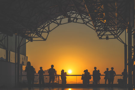 Silhouetted visitors line a waterfront promenade as the sun sets Nov 16 2025のeditorial素材