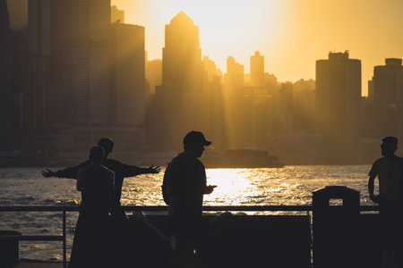 Golden sunset over a modern city skyline casts long shadows Nov 16 2025のeditorial素材