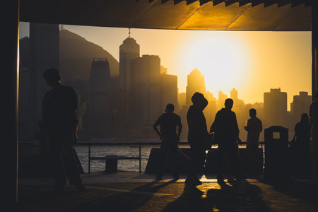 Golden sunset over a modern city skyline casts long shadows Nov 16 2025のeditorial素材