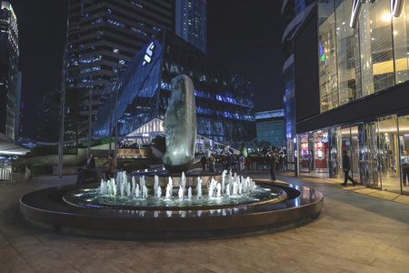 A nighttime view of a circular fountain surroundingのeditorial素材