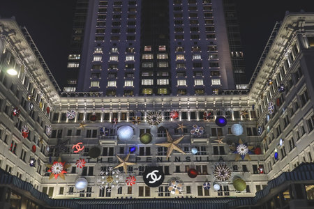 Nighttime view of a white, ornate building adorned with oversized Christmas