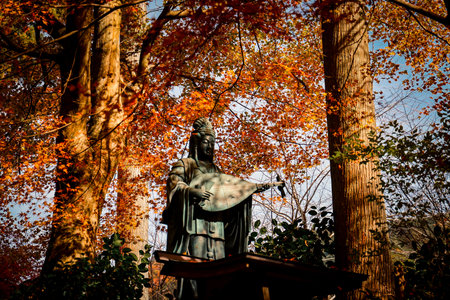 Serene Guanyin Statue with Pipa Surrounded by Autumn Foliage Nov 23 2025のeditorial素材