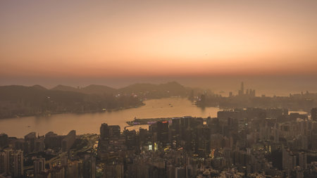 glowing sky highlights Hong Kong buildings and distant mountains Jan 18 2026のeditorial素材