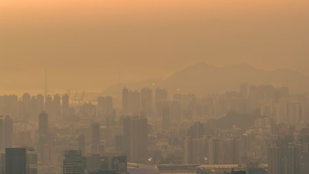 Thick smog obscures dense city buildings under muted daylight Jan 18 2026のeditorial素材
