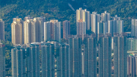 Dense residential towers contrast sharply with surrounding green mountains Jan 25 2026のeditorial素材