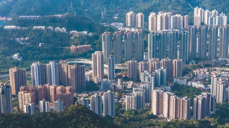 Dense residential towers contrast sharply with surrounding green mountains Jan 25 2026のeditorial素材