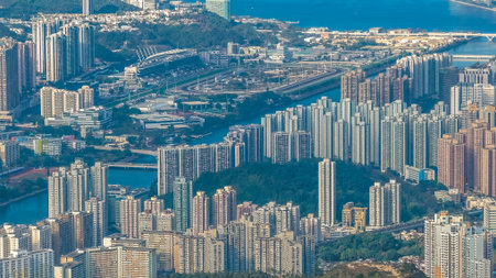 Urban skyline stretches across valley beneath surrounding green mountains Jan 25 2026のeditorial素材