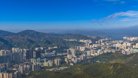 Urban skyline stretches across valley beneath surrounding green mountains Jan 25 2026