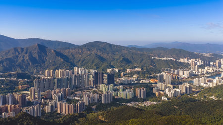 Urban skyline stretches across valley beneath surrounding green mountains Jan 25 2026