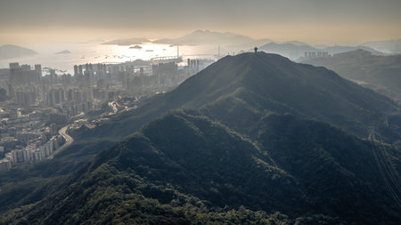 Mountain ridge overlooks dense Kowloon skyline stretching toward harbour Jan 25 2026のeditorial素材