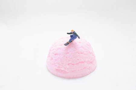 Miniature snowboarder rides atop colorful steamed cakeの写真素材