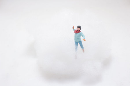 Tiny winter character posed inside fluffy cloudlike artificial snowの写真素材