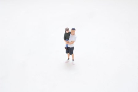Tiny figurine depicts caring parent lifting young child