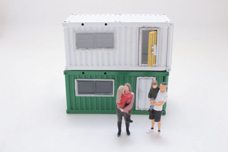 Tiny figurines depict parents with children near container homeの写真素材