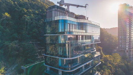 Modern glass clad architecture stands proudly beside green mountain backdrop Feb 14 2026