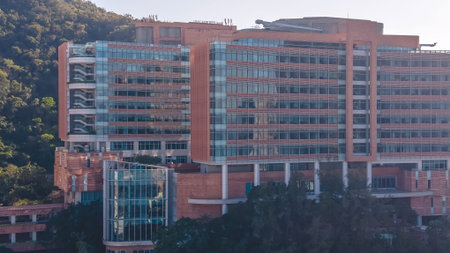 Contemporary academic buildings extend across elevated green university grounds Feb 14 2026
