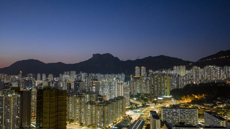 Illuminated residential towers rise above bustling evening district Feb 15 2026のeditorial素材