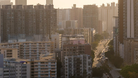 Layered residential towers rise across golden haze filled evening landscape Feb 15 2026のeditorial素材