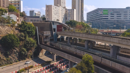 Electric commuter train moves across elevated tracks beside buildings Feb 16 2026