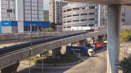 Electric commuter train moves across elevated tracks beside buildings Feb 16 2026