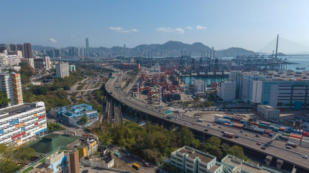 Major elevated highway curves beside cranes and distant mountains Feb 16 2026