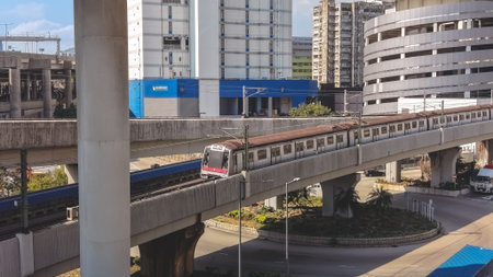 Electric commuter train moves across elevated tracks beside buildings Feb 16 2026