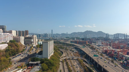 Major elevated highway curves beside cranes and distant mountains Feb 16 2026