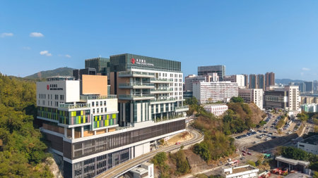 Large medical complex rises prominently beside green sloping terrain Feb 16 2026