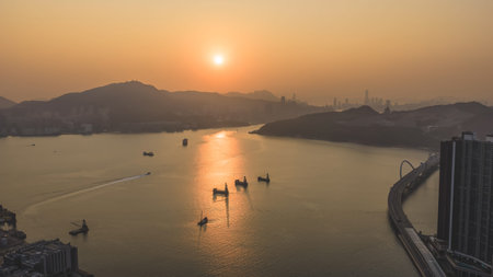 Golden sun descends over boats, coastline, bridge, and distant hills Feb 22 2026