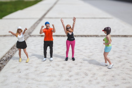 Tiny figurines pose in lively stances across bright open walkwayの写真素材