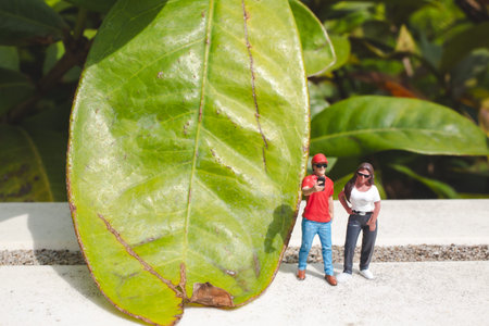 Tiny figurines pose closely holding smartphone on outdoor platform
