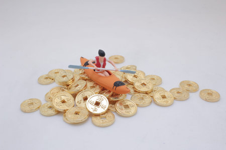 Miniature model in kayak posed atop metallic tokens