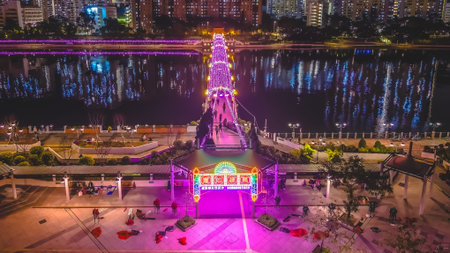 Colorful neon gateway leads to glowing riverside pedestrian bridge Feb 1 2026のeditorial素材