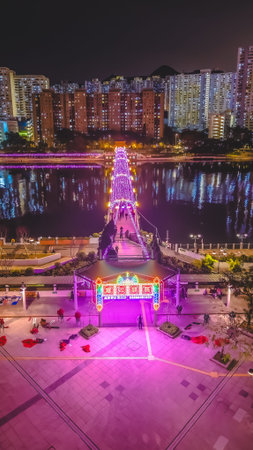 Colorful neon gateway leads to glowing riverside pedestrian bridge Feb 1 2026のeditorial素材