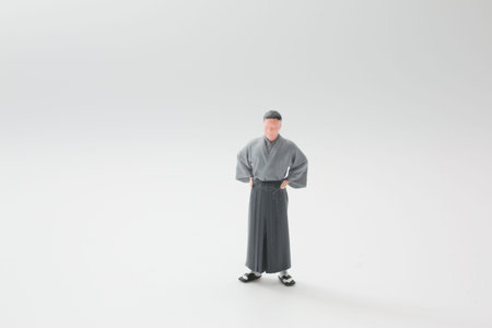 Small figure in traditional clothing stands centered with poiseの写真素材